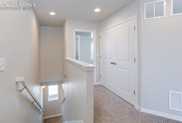 hallway with light colored carpet