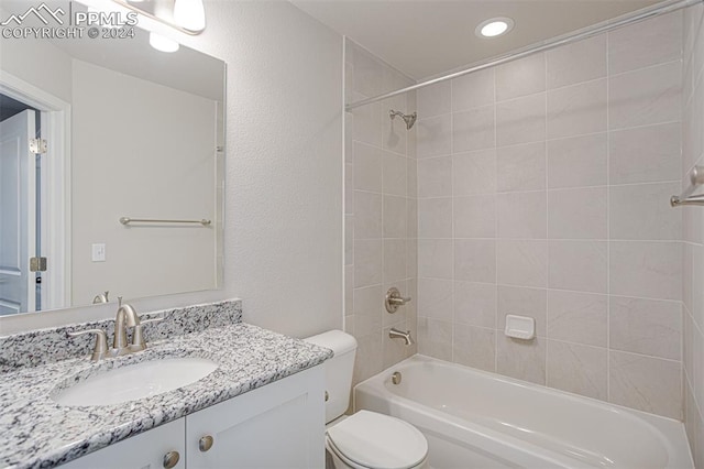 full bathroom featuring toilet, tiled shower / bath combo, and vanity