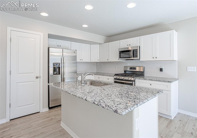 kitchen with white cabinetry, appliances with stainless steel finishes, and an island with sink