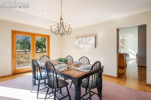 dining room with light hardwood / wood-style floors and an inviting chandelier