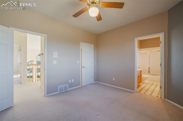 unfurnished bedroom featuring connected bathroom, light carpet, and ceiling fan