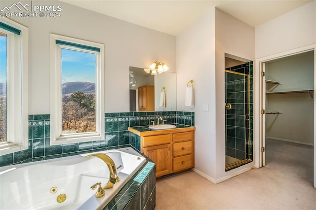 bathroom with vanity, independent shower and bath, and plenty of natural light