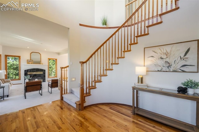 stairs featuring hardwood / wood-style flooring and a tile fireplace