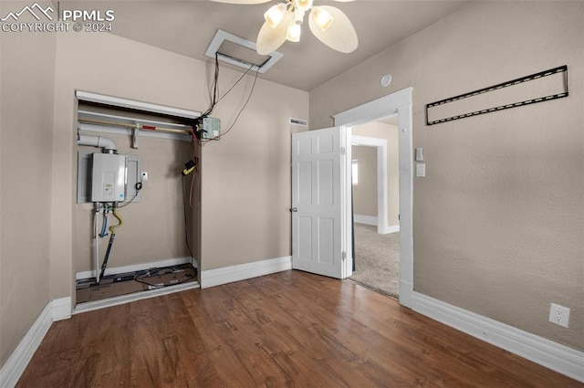 workout area featuring water heater, hardwood / wood-style flooring, and ceiling fan