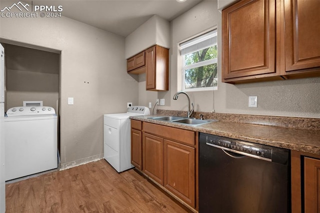 kitchen featuring light hardwood / wood-style flooring, stainless steel dishwasher, sink, and washing machine and dryer