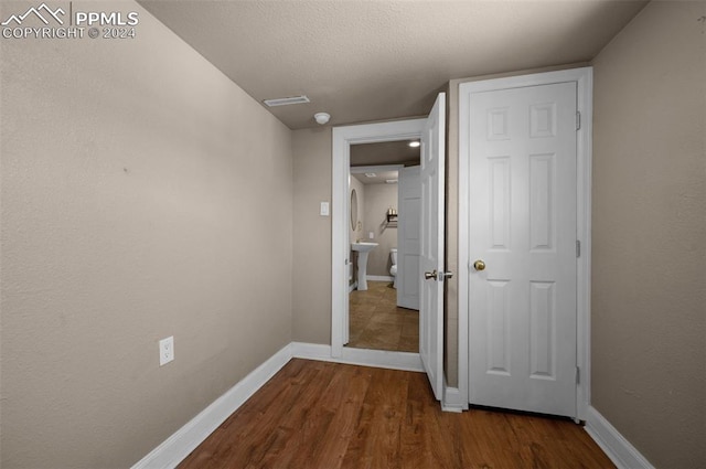 hallway featuring a textured ceiling and hardwood / wood-style flooring