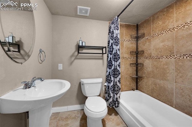 full bathroom with sink, shower / bath combination with curtain, a textured ceiling, and toilet