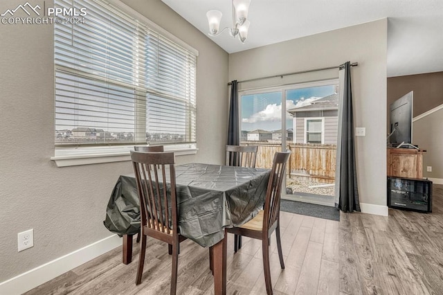 dining space featuring hardwood / wood-style flooring and an inviting chandelier