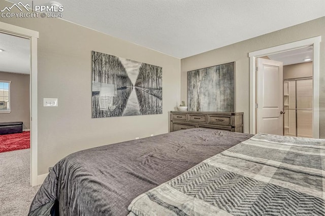 bedroom featuring carpet flooring and a textured ceiling