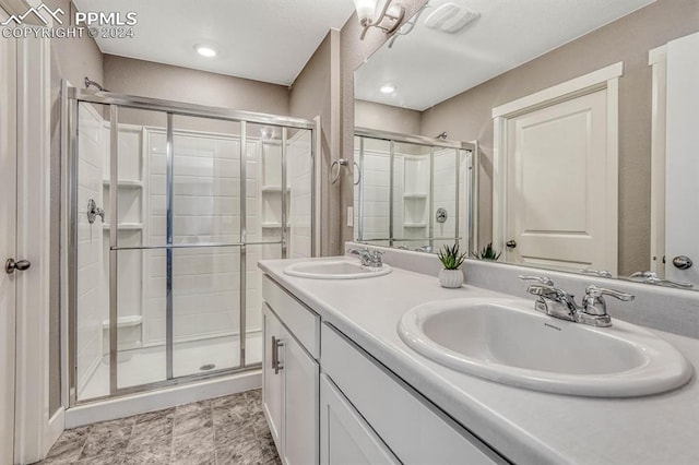 bathroom featuring vanity and a shower with door