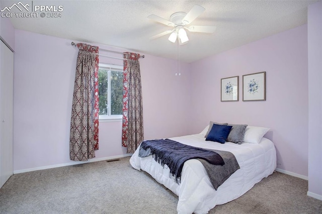 carpeted bedroom with a textured ceiling and ceiling fan