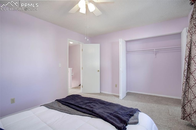 bedroom featuring a closet, ceiling fan, a textured ceiling, and light colored carpet