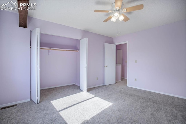 unfurnished bedroom featuring light carpet, a closet, and ceiling fan