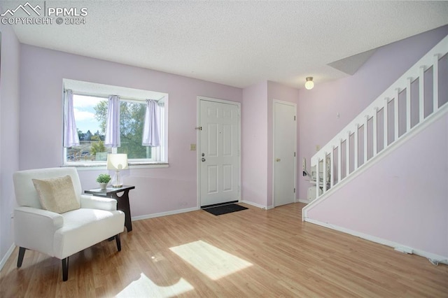 entryway with hardwood / wood-style floors and a textured ceiling