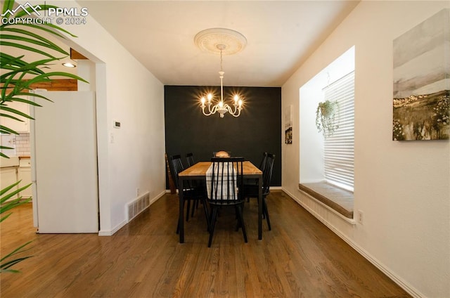 dining room featuring a notable chandelier and dark hardwood / wood-style floors