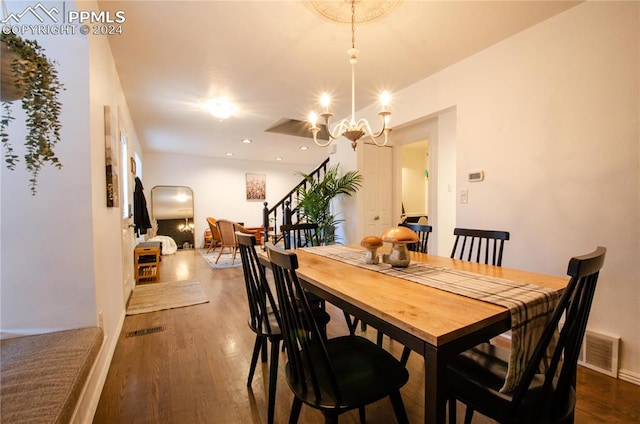 dining room with dark hardwood / wood-style floors and a chandelier