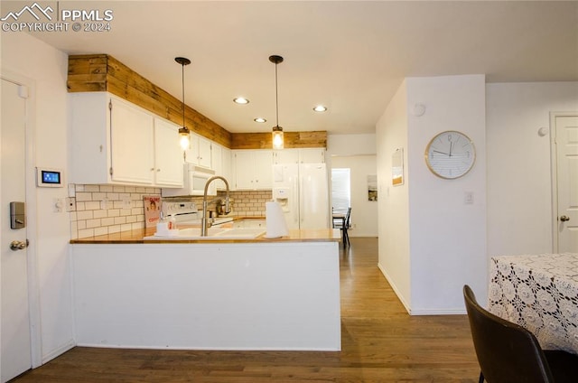 kitchen with dark wood-type flooring, hanging light fixtures, kitchen peninsula, white cabinetry, and white appliances