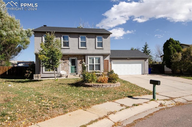 view of front of property featuring a front yard and a garage