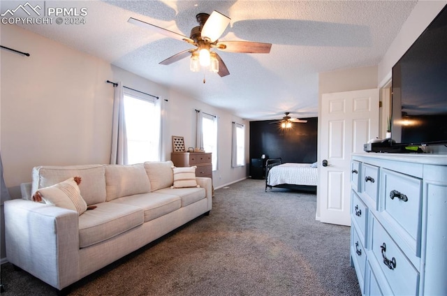 bedroom featuring dark colored carpet, a textured ceiling, and ceiling fan