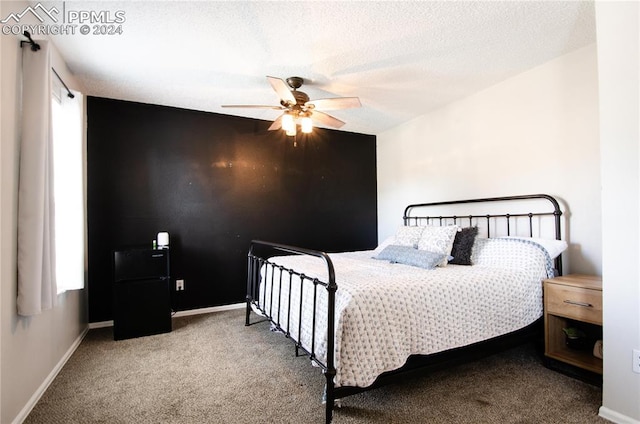 carpeted bedroom with a textured ceiling and ceiling fan