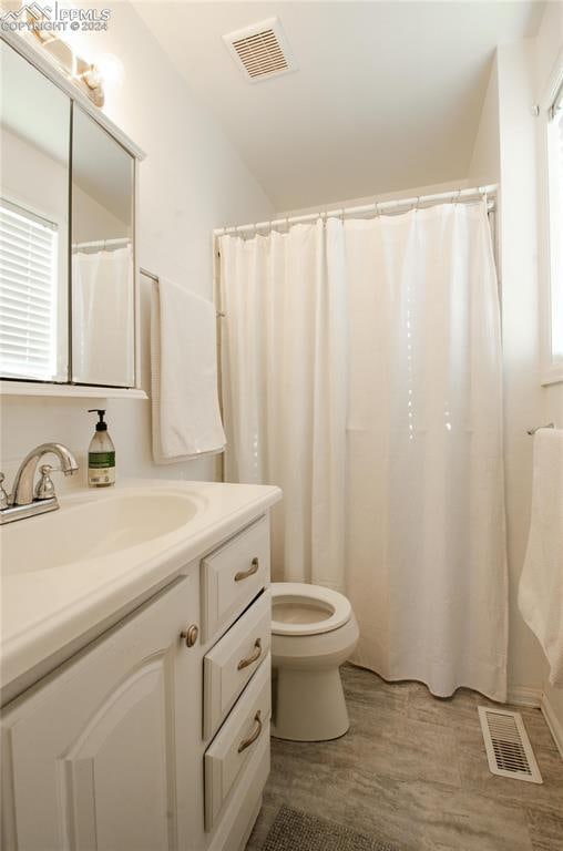 bathroom featuring vanity, hardwood / wood-style flooring, toilet, and a shower with shower curtain