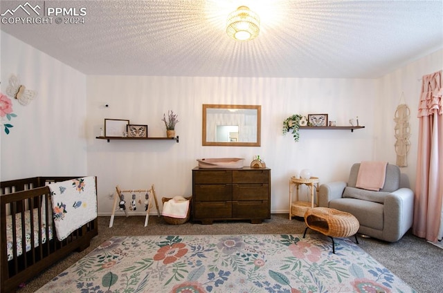 bedroom with a textured ceiling, carpet flooring, and a crib