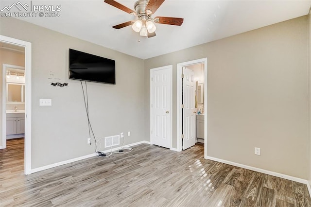 unfurnished bedroom with connected bathroom, ceiling fan, and light hardwood / wood-style floors