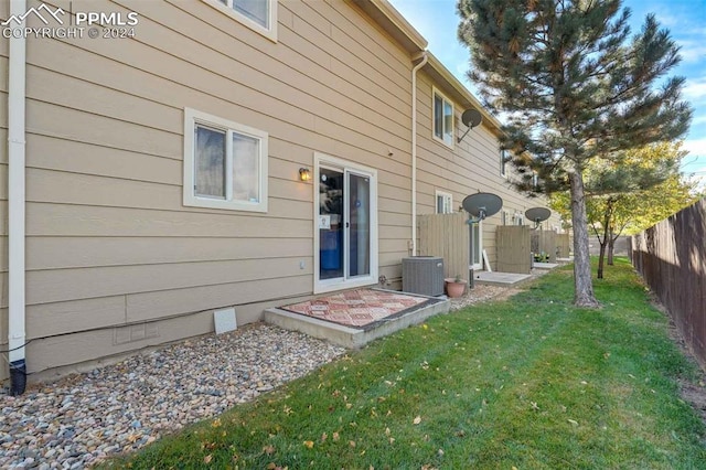 back of property featuring a yard and central AC unit