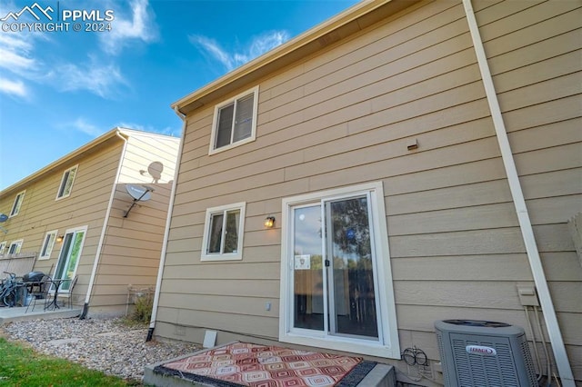 rear view of property featuring a patio and central AC