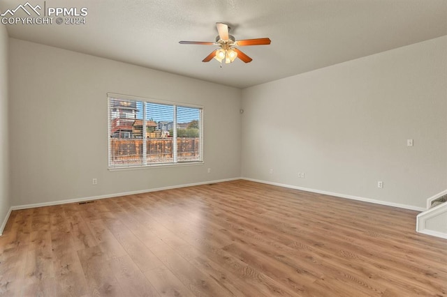 unfurnished room with ceiling fan and light wood-type flooring