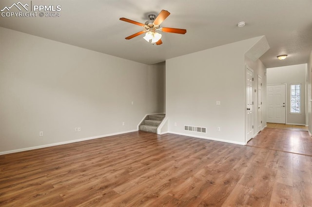 unfurnished living room with wood-type flooring and ceiling fan