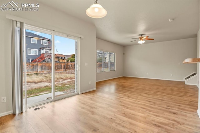 unfurnished living room featuring light wood-type flooring and ceiling fan