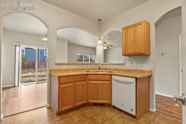 kitchen featuring white dishwasher, light hardwood / wood-style floors, sink, and hanging light fixtures