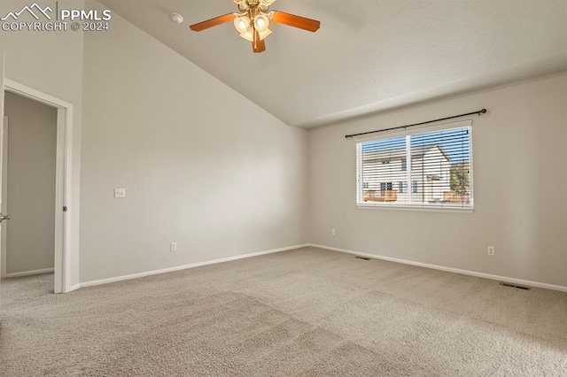 carpeted spare room featuring ceiling fan and vaulted ceiling