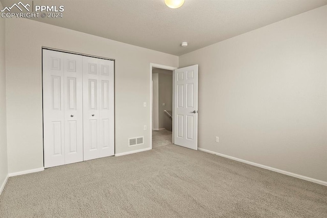 unfurnished bedroom with carpet flooring and a closet