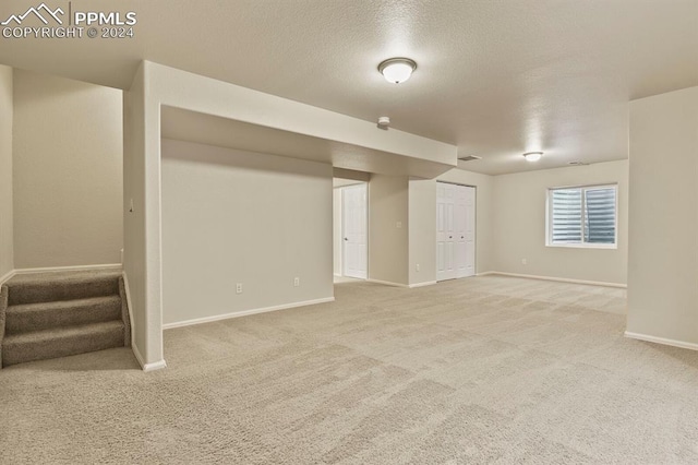 basement with carpet and a textured ceiling