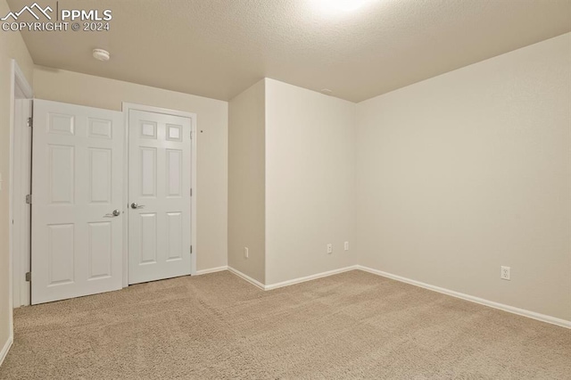 carpeted empty room featuring a textured ceiling