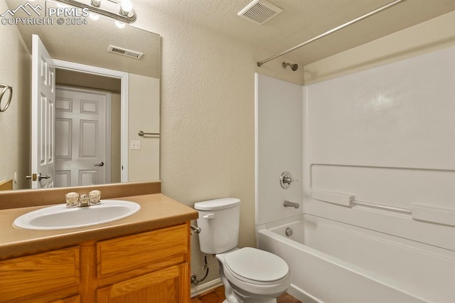 full bathroom with vanity,  shower combination, toilet, and a textured ceiling