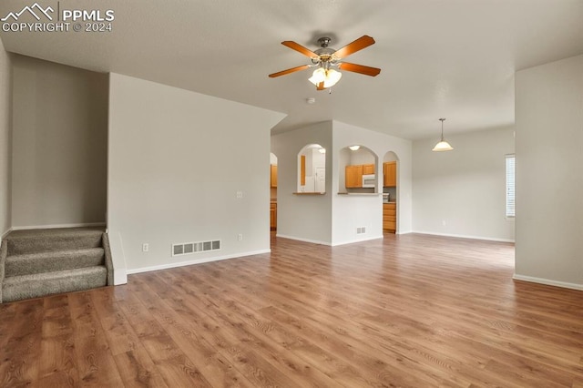 unfurnished living room featuring wood-type flooring and ceiling fan