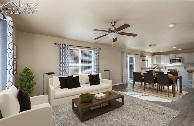 living room featuring ceiling fan and light hardwood / wood-style floors