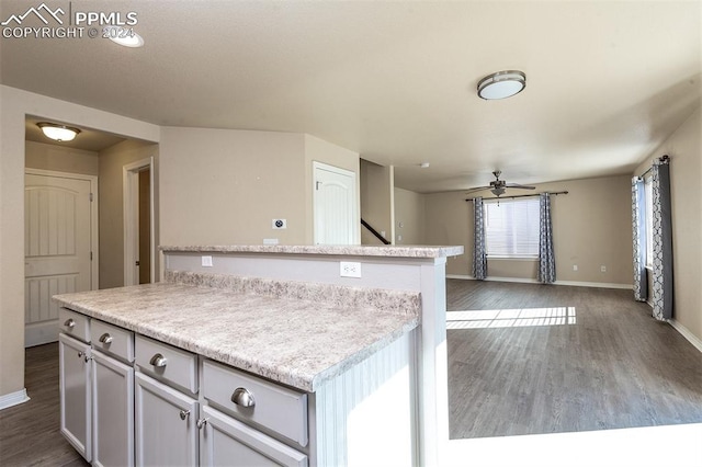 kitchen featuring a kitchen island, ceiling fan, and dark hardwood / wood-style floors