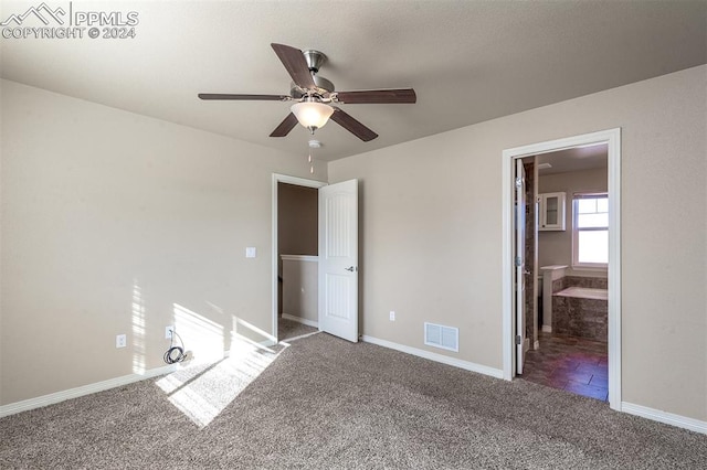 unfurnished bedroom featuring ceiling fan, ensuite bath, and carpet