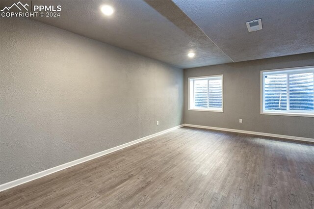 unfurnished room featuring wood-type flooring and a textured ceiling