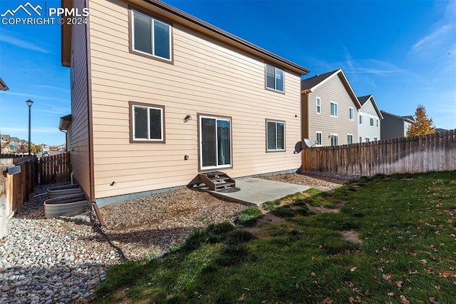 back of property featuring a patio and a lawn