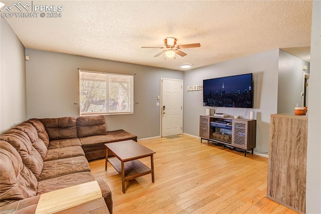 living room with ceiling fan, wood-type flooring, and a textured ceiling