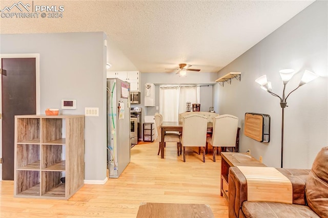 dining room with a textured ceiling, light hardwood / wood-style floors, and ceiling fan