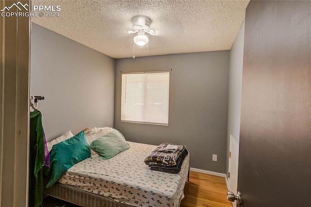 bedroom with light hardwood / wood-style floors and a textured ceiling