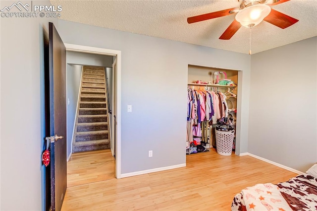 bedroom featuring a textured ceiling, hardwood / wood-style flooring, a closet, and ceiling fan