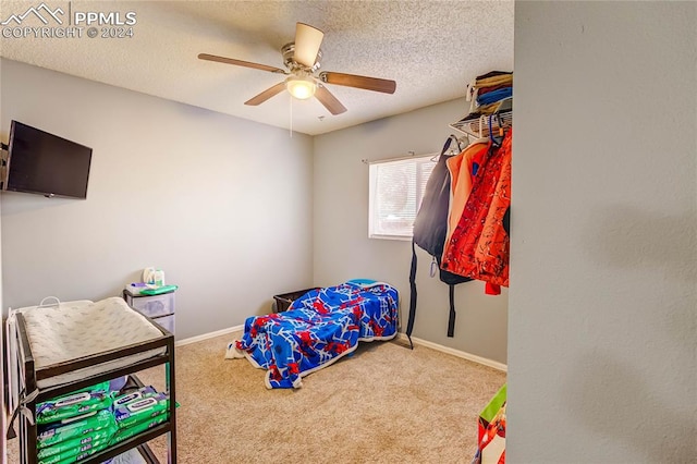 bedroom with carpet floors, a textured ceiling, and ceiling fan