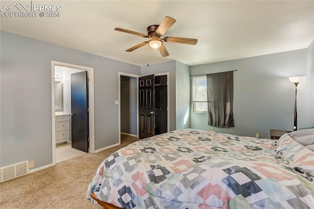 bedroom with light carpet, connected bathroom, and ceiling fan